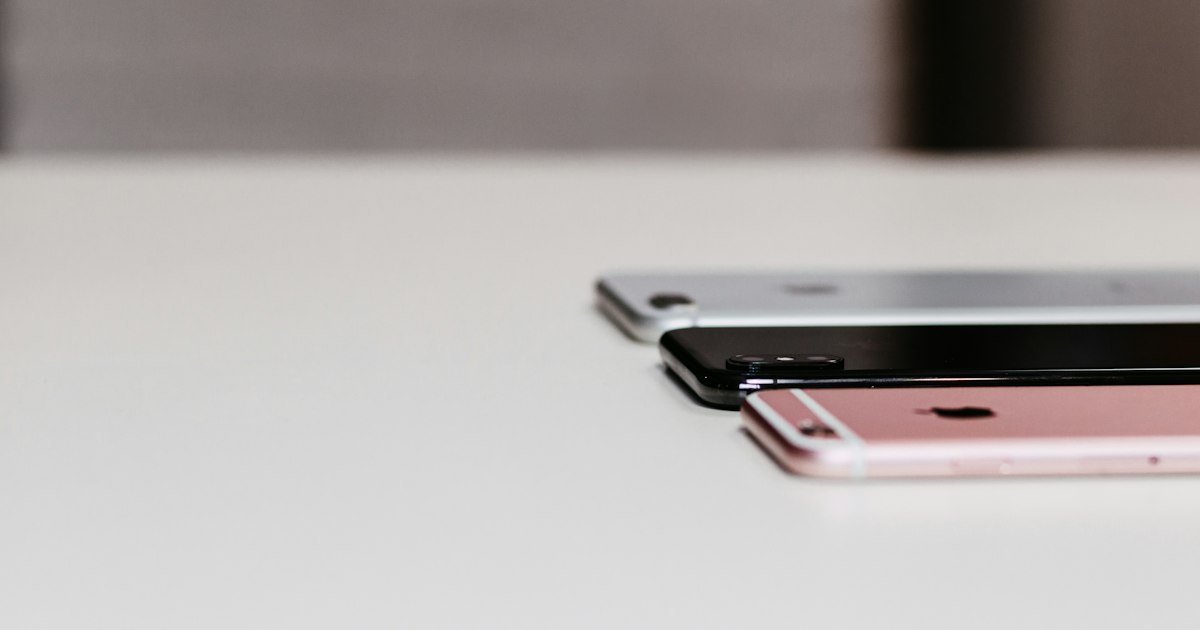Three smartphones lined up on a table