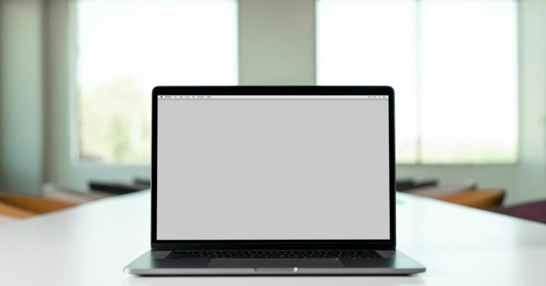 Laptop open on a desk in a bright workspace