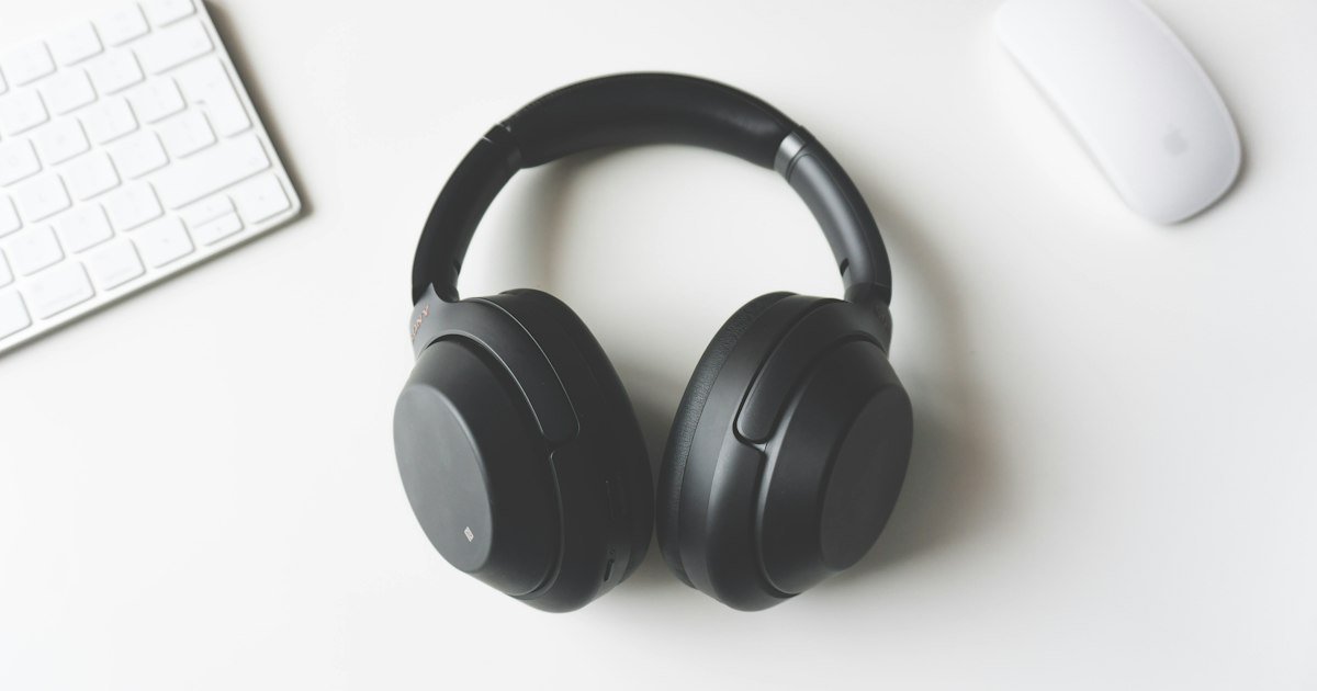 Black wireless headphones on a white desk
